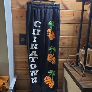 Chinatown Market Black Sweatpants with Orange Graphics